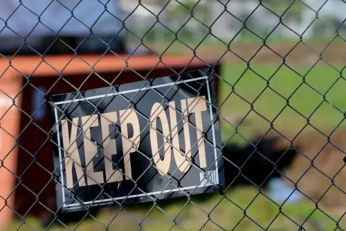 Fence with, "Keep out" sign.  Illustrating greed.  Part of the equation of if greed causes inflation.